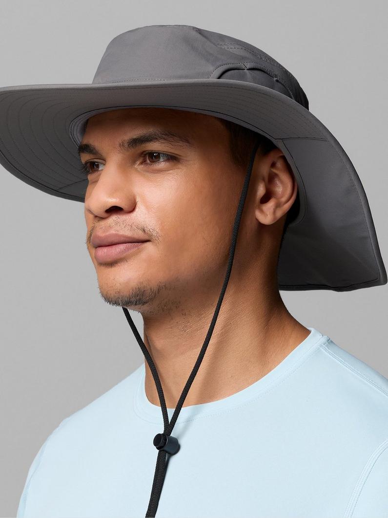 Gray wide-brim sun hat with neck flap and adjustable chin strap, worn by a man in light blue shirt.