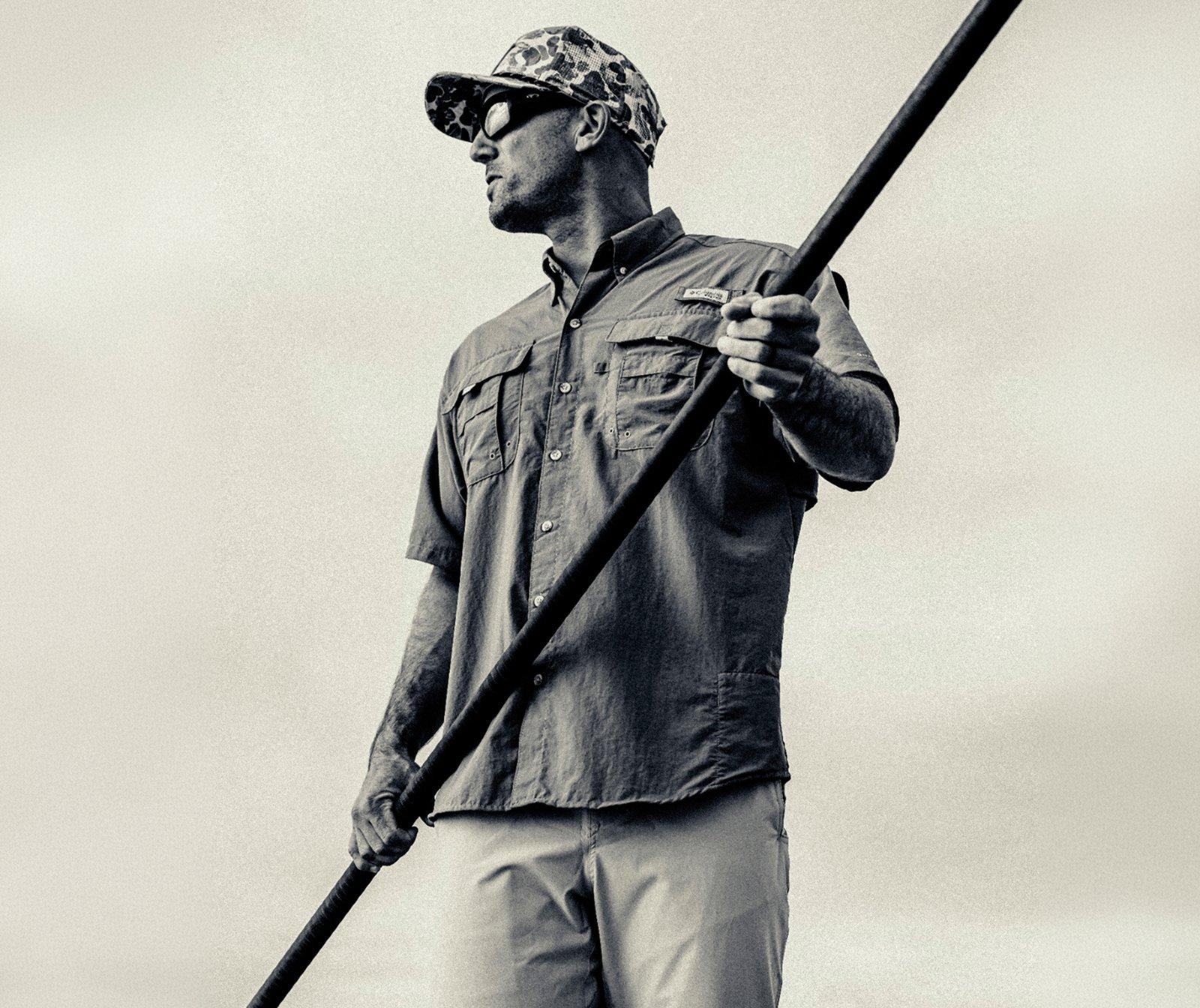 Sepia toned photo of a man wearing a Columbia fishing shirt and camo hat