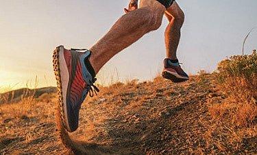 A man lacing up a hiking shoe with TechLite cushioning.