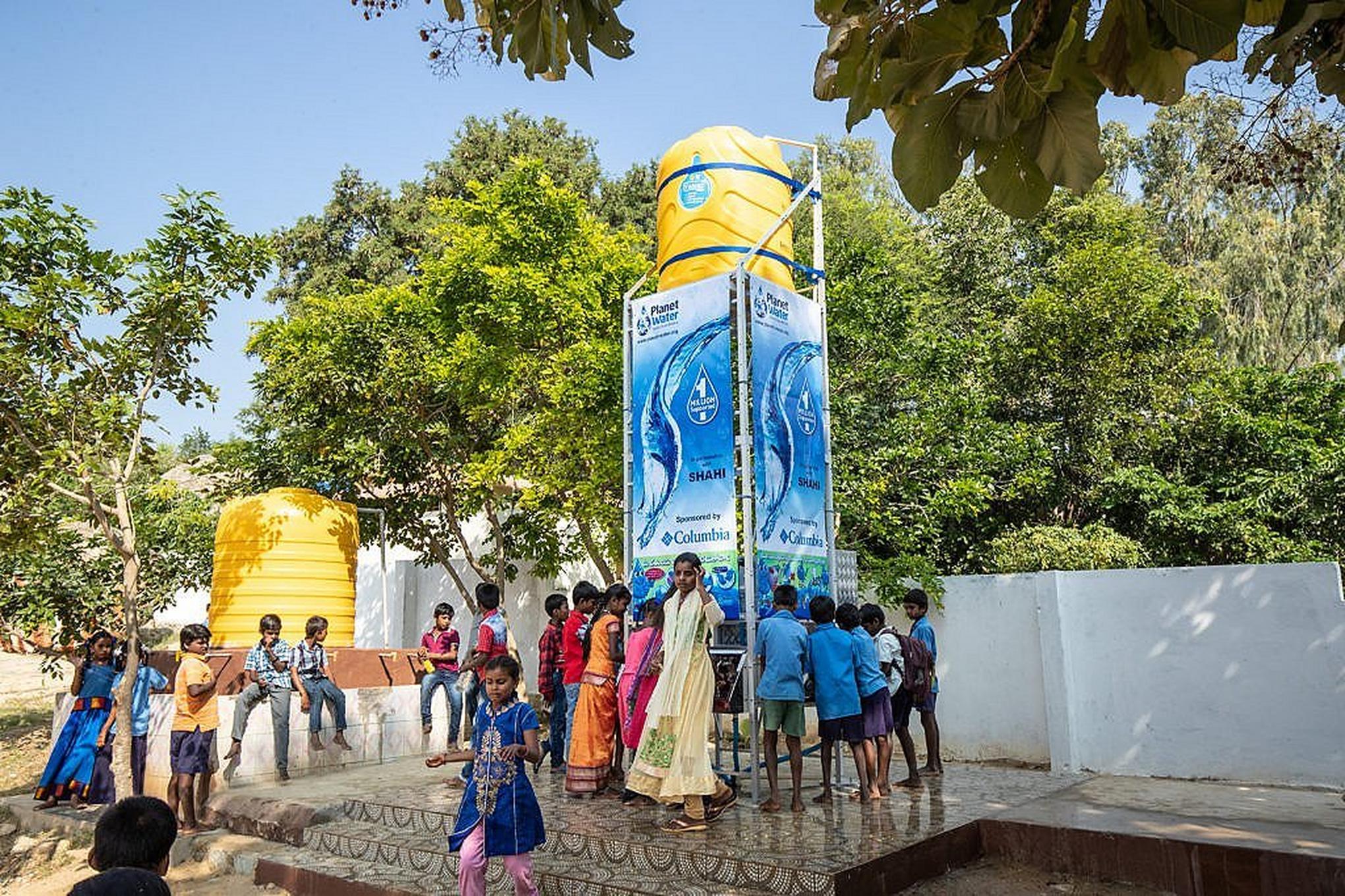 Group gathered around a clean water tower.