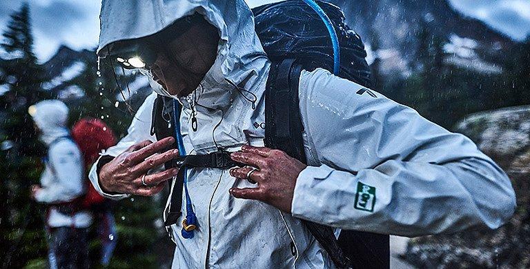 A person wearing an OutDry Extreme Eco jacket in a rainstorm. 