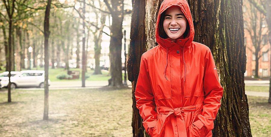 Woman in a park wearing a red Columbia Sportswear jacket.