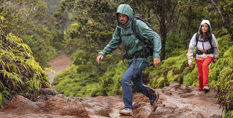 Two people hiking in the rain wearing Columbia Sportswear gear.