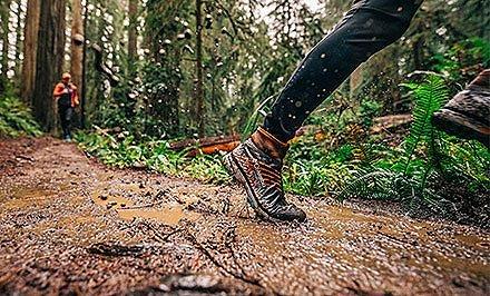 Close-up of a trail runner with shoes featuring FluidFoam cushioning.