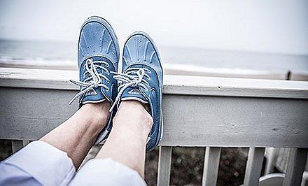 A person wearing shoes with Omni-Shield by the ocean.