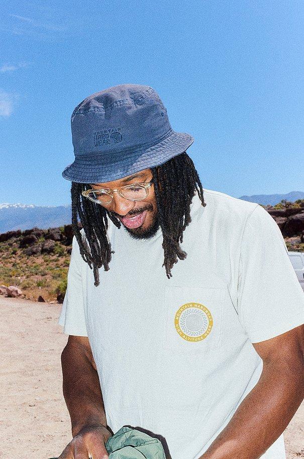Caleb smiling at the ground behind a blue sky.