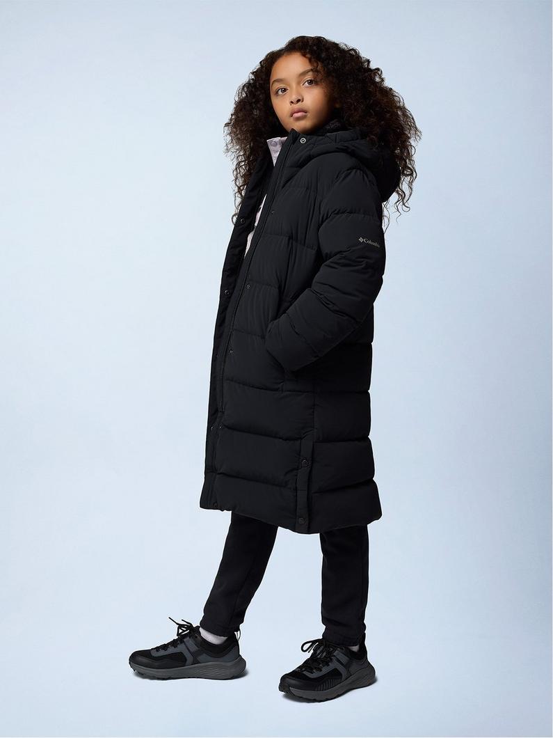 Woman wearing black knee-length puffer coat with hood, black pants, and black sneakers.