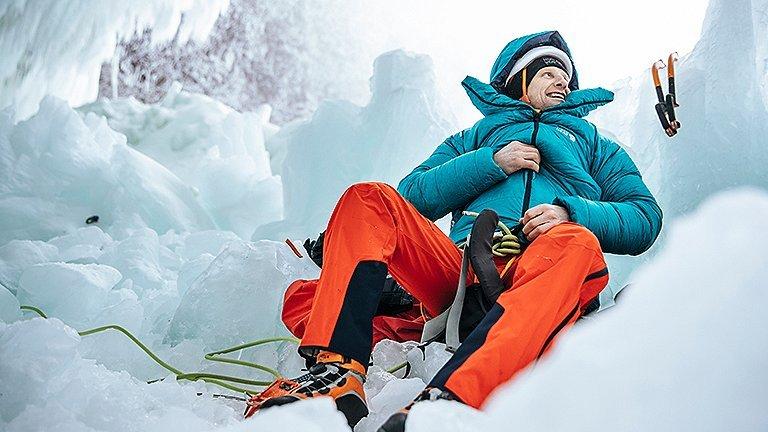 Mountain Hardwear athlete Tim Emmett zipping up a jacket, getting ready for an ice climb
