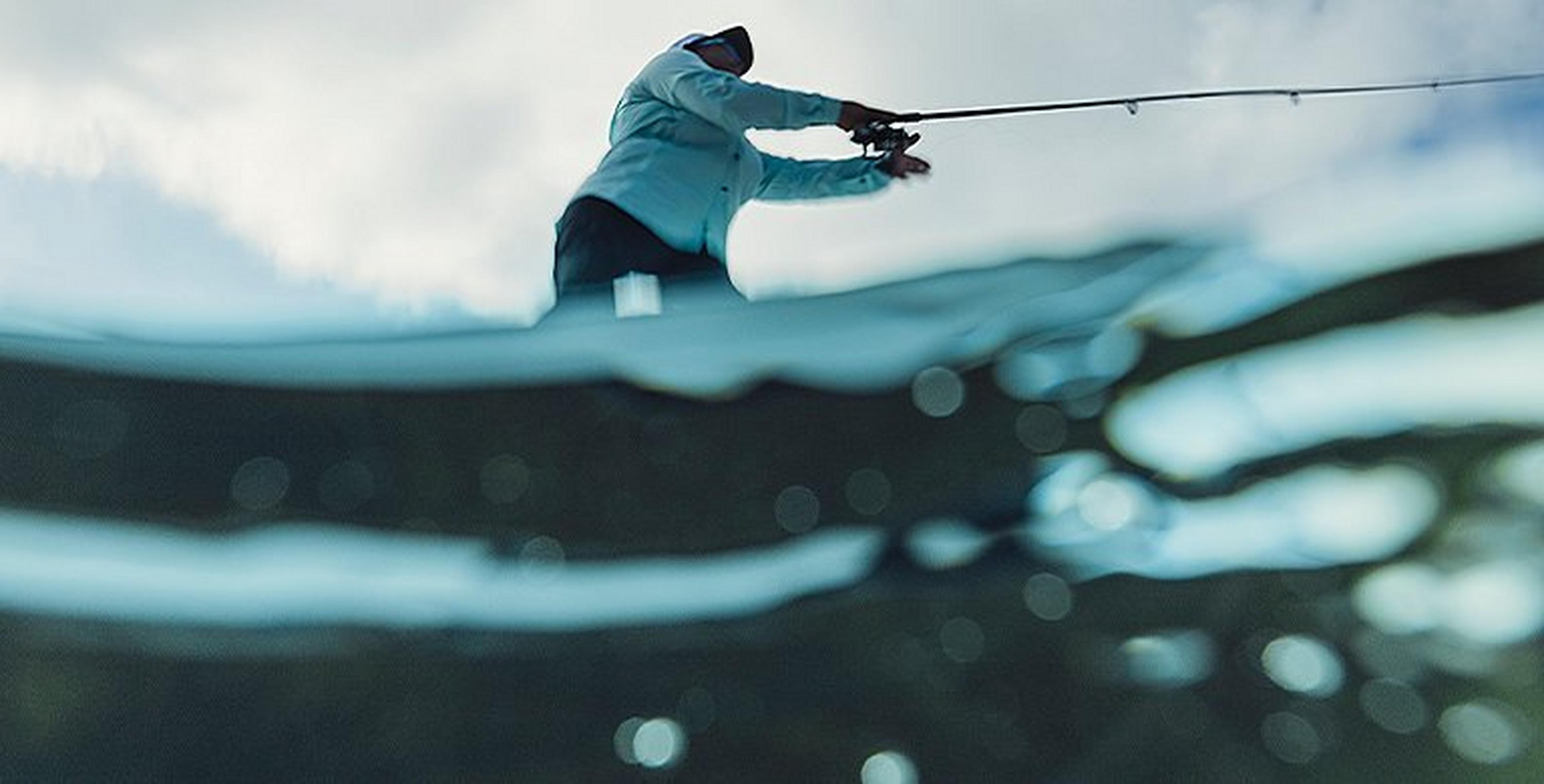 Person fishing viewed from just below the water line
