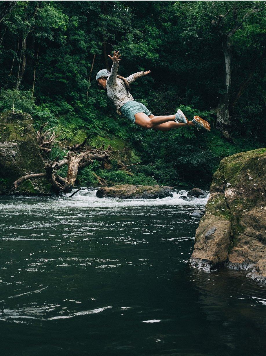 Woman in mid-air, diving into water.