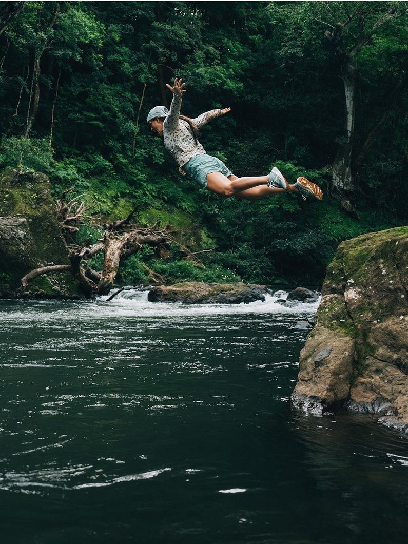 Woman in mid-air, diving into water.