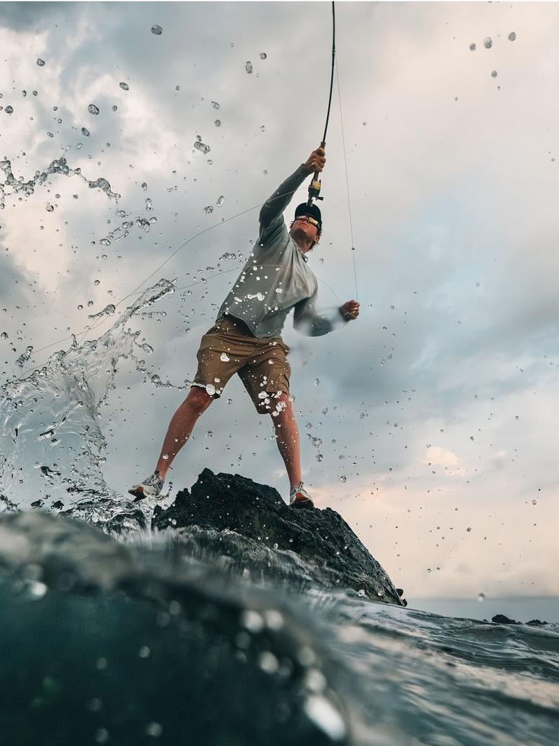 Angler casting his line in splashy, intense water.