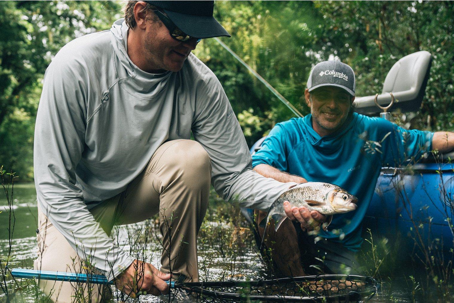 Angler in the jungle holding a fish.