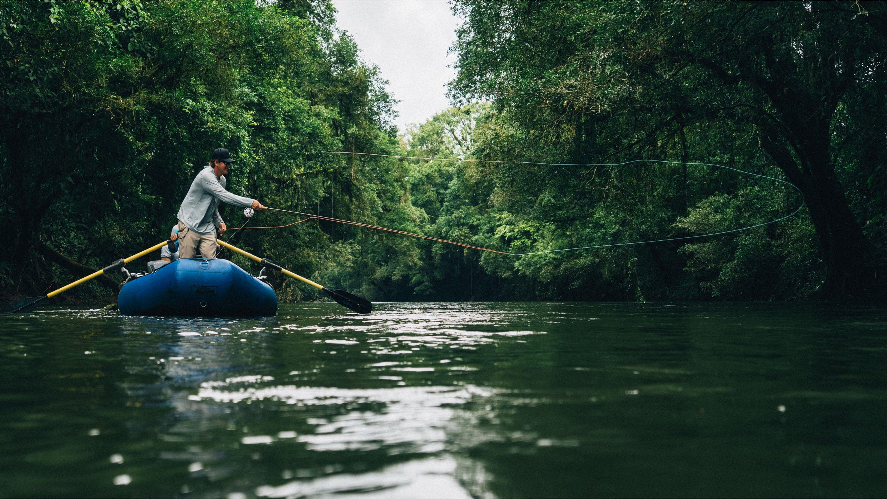 People in a boat fishing on a jungle river.