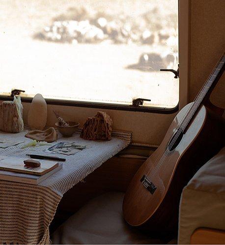 A small dining nook nestled in a warm home with a guitar.