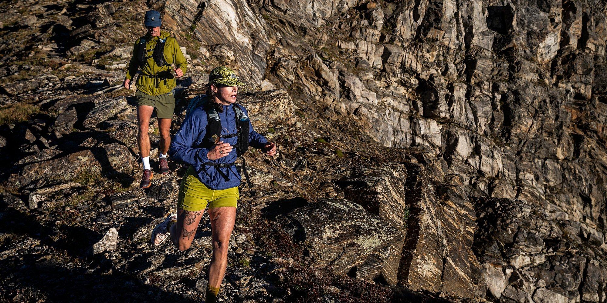 Two runners trail running in the Kor AirShell hoody in the high alpine.