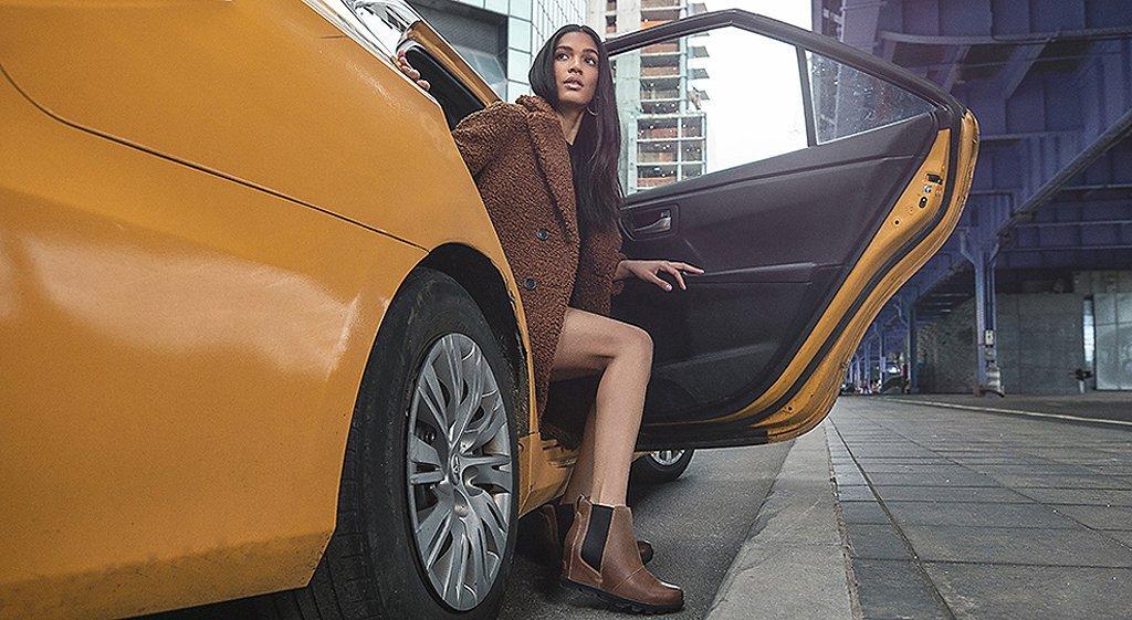 Three images of women wearing Joan Wedge boots walking through the city