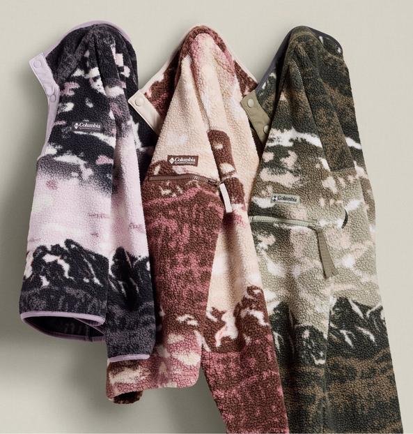 Three colorful fleece jackets hanging on hooks