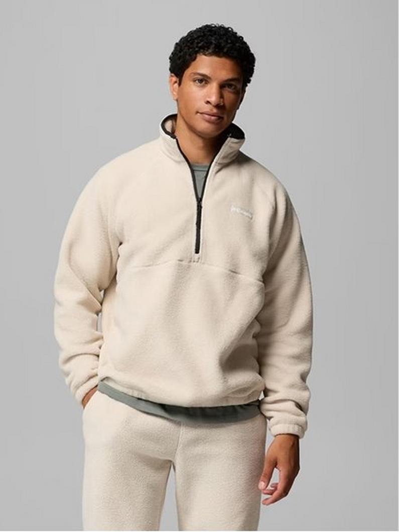 A man wearing a green fleece zip up with text: Fleece