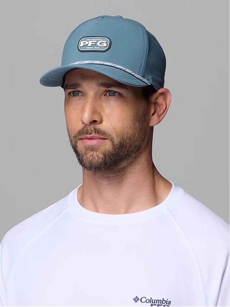 Man wearing a blue and navy trucker hat with white logo patch and white t-shirt.