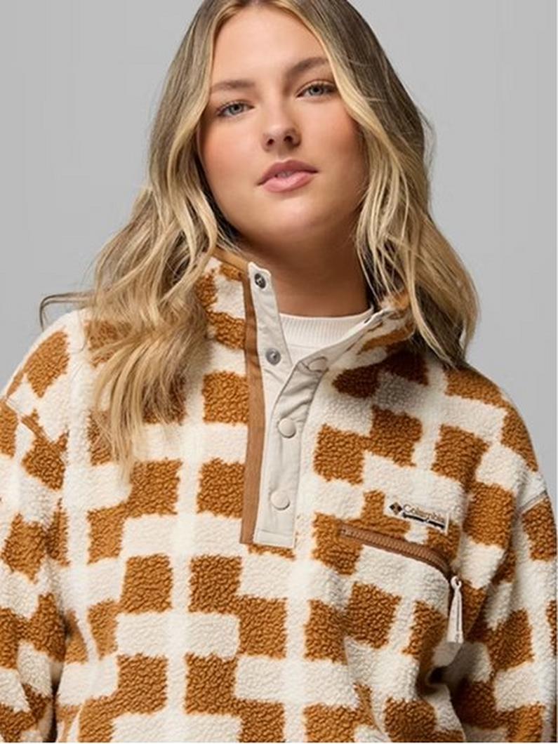 Woman wearing a cream and brown checkered fleece pullover with button neck closure and chest pocket.