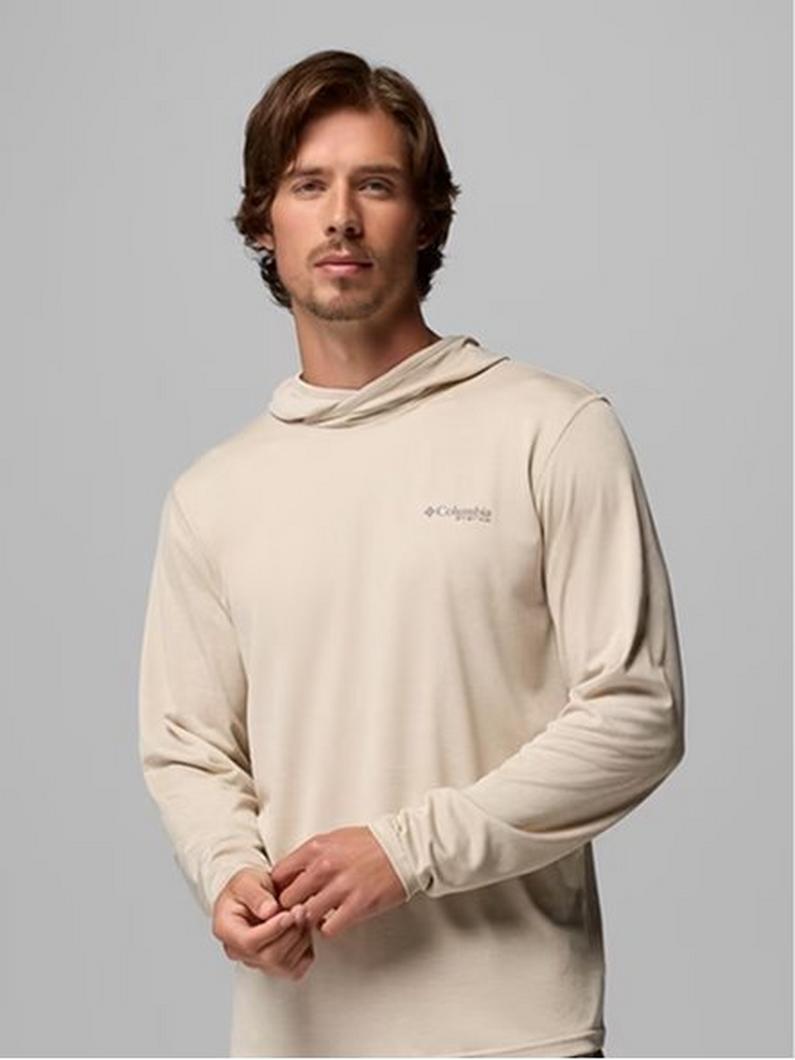 Man wearing a beige long-sleeve hooded shirt with small chest logo.