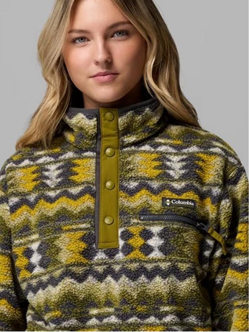 Woman wearing a patterned fleece pullover with geometric design in yellow, olive, and cream tones.