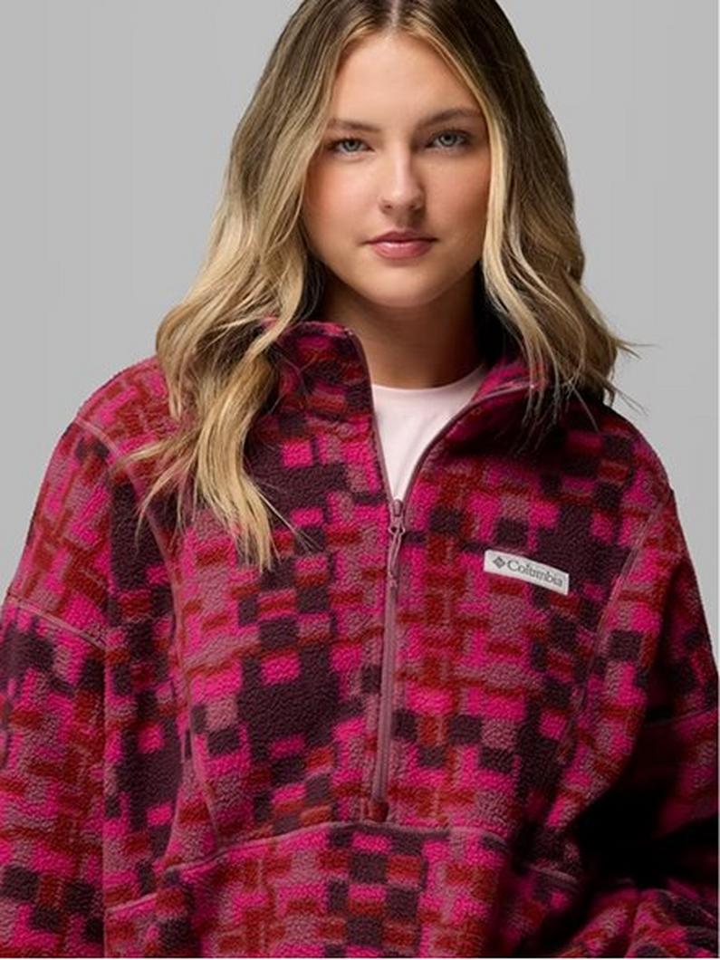 Woman wearing pink and burgundy checkered fleece quarter-zip pullover over white top.