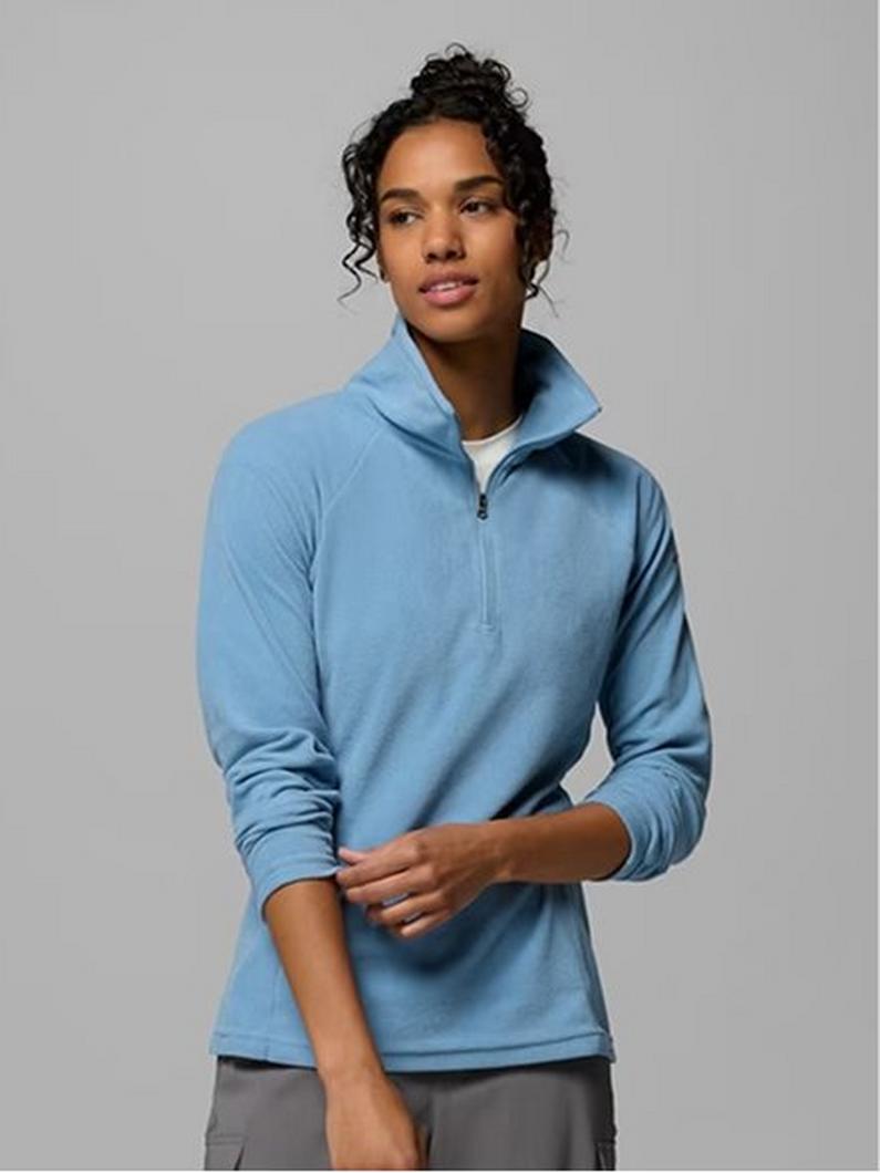 Woman wearing a light blue quarter-zip fleece pullover with gray pants.