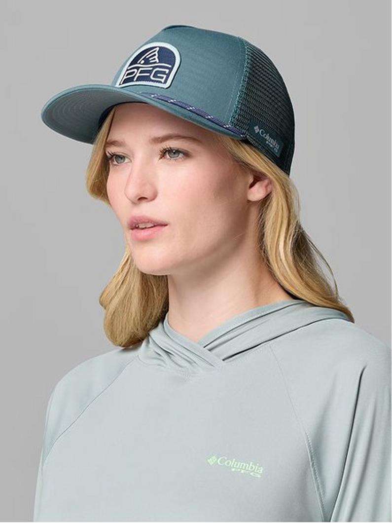 Woman wearing a teal trucker hat with mesh back and light green performance hoodie.