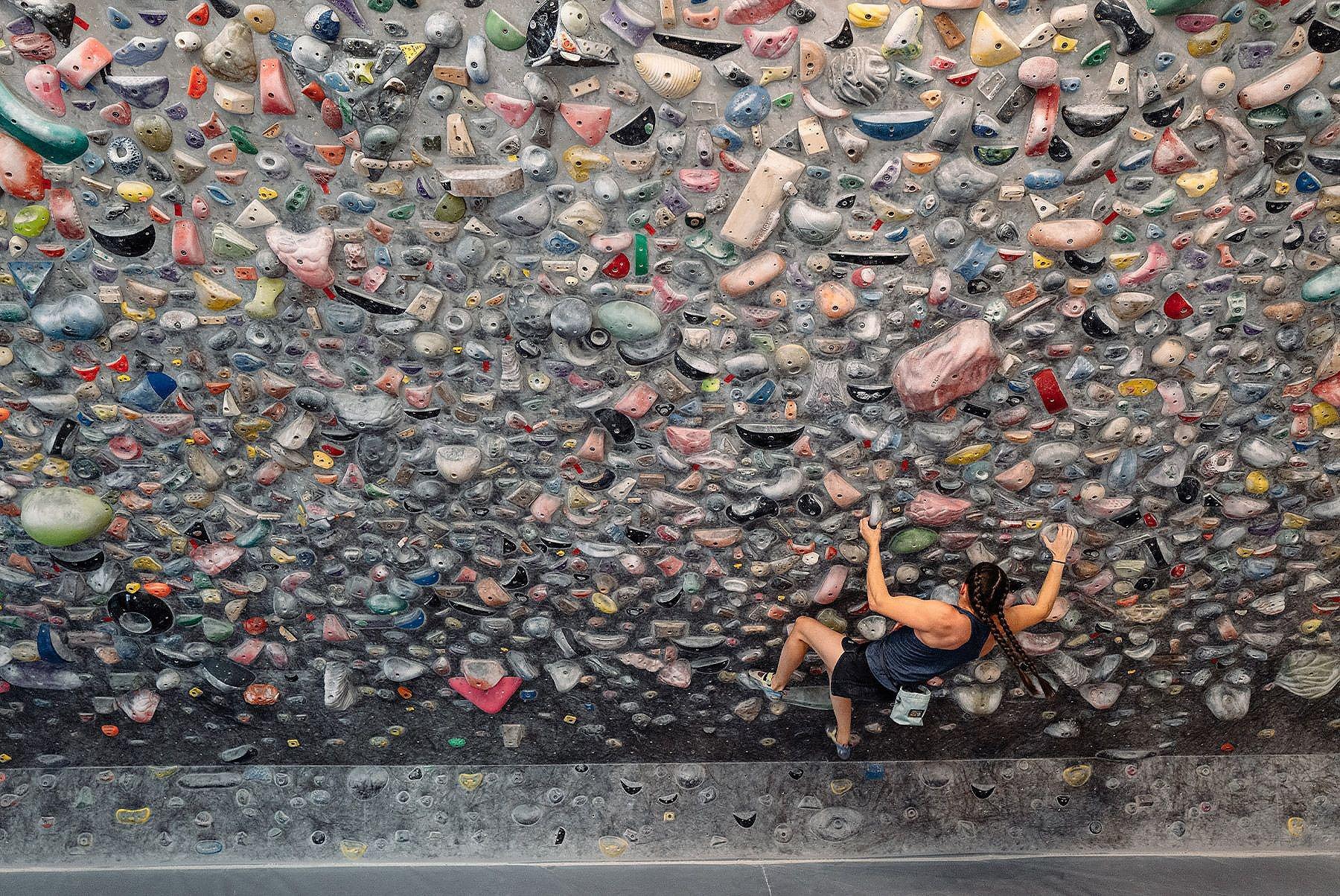 Kyra working on a challenging bouldering problem at the gym
