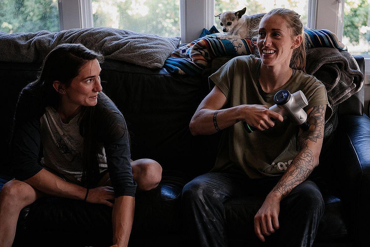 Kyra and Alex sit on the couch, in coversation