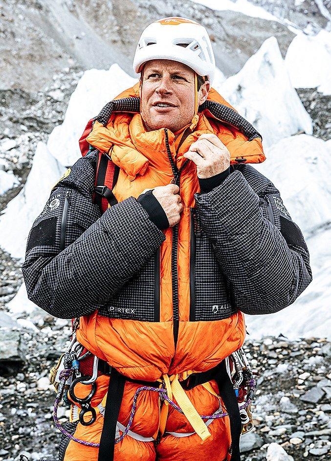 Alex Johnson climbing in a climbing gym, pretty close to the top of the route.