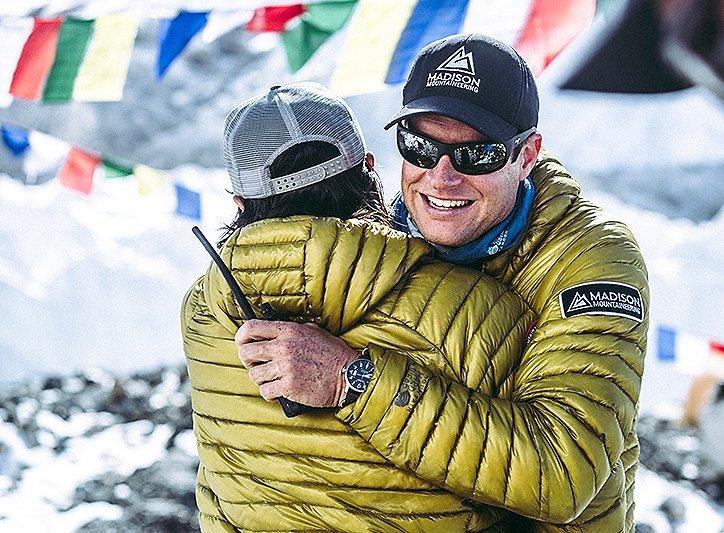 Garrett Madison embraces one of the sherpa at Everest Base Camp wearing the Ghost Whisperer down jacket.