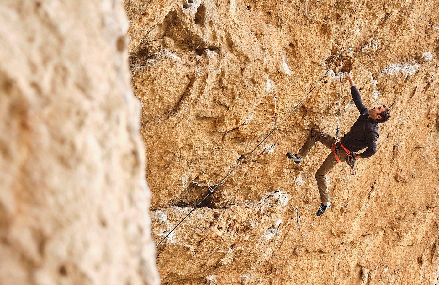 Chris Sharma climbing a rough cliff face.