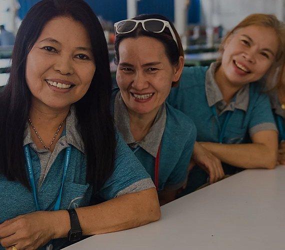 An image of three women who work at a Fair Trade Certified Factory represents Fair Trade. 
